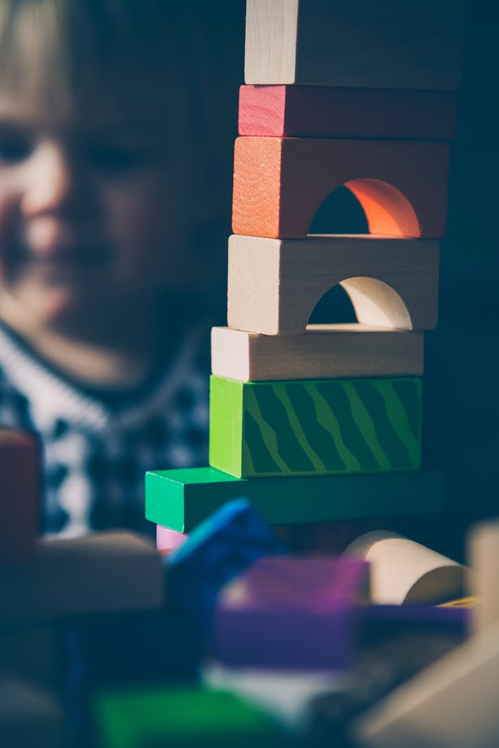 A child plays with colorful wooden blocks, building creative structures.