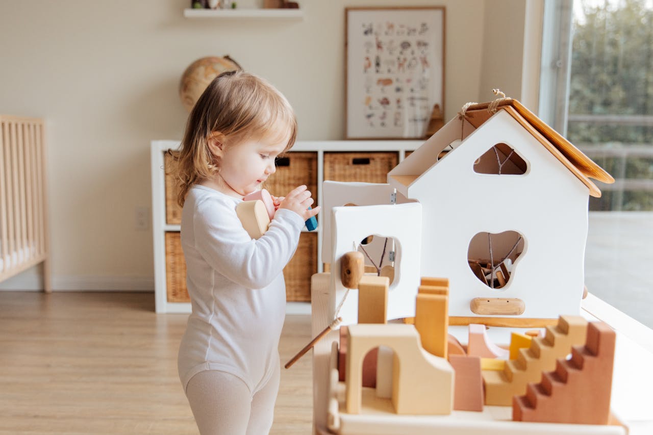 Cute toddler engaging with wooden toys in a bright indoor setting.