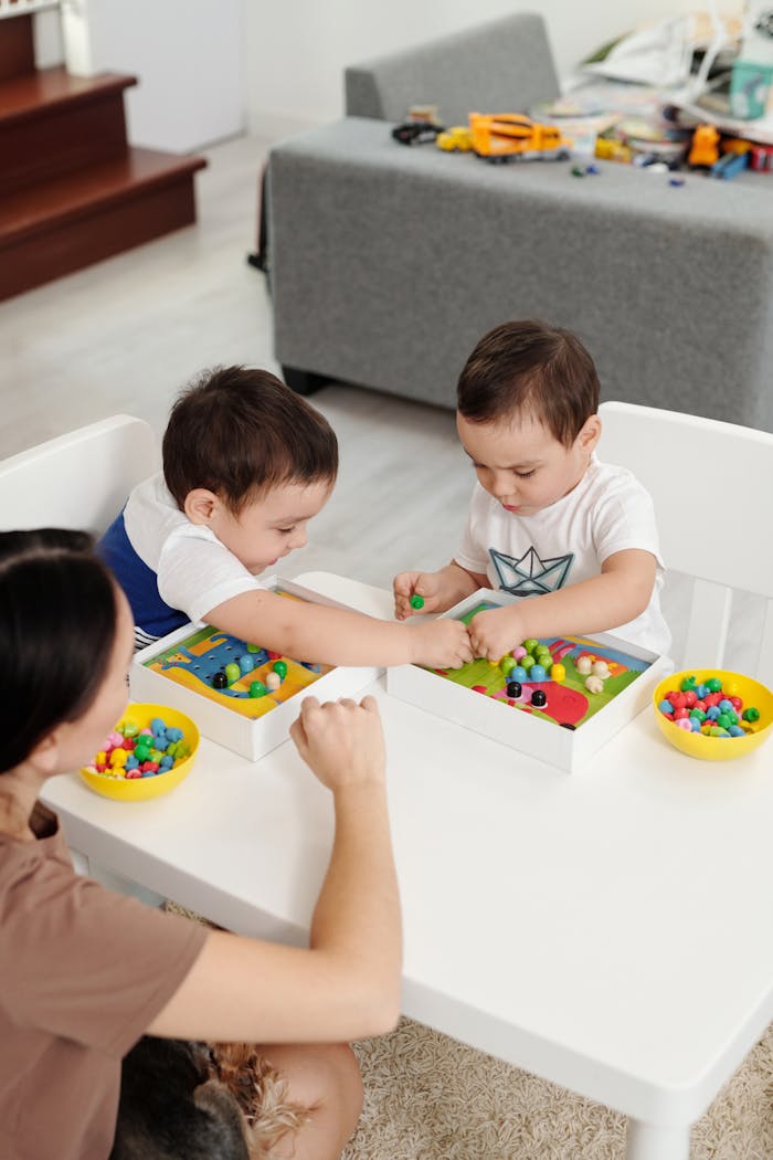 Two young children engaged with educational toys at home, supervised by a parent.