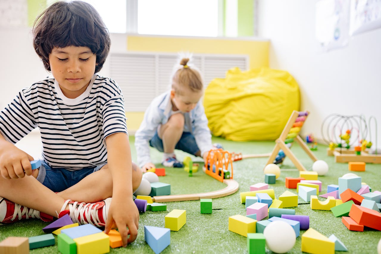 Kids enjoying playtime with toys and blocks in a bright kindergarten classroom.